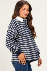 woman wearing a navy and gray striped maternity top with a white collar and balloon sleeves, showing no baby bump