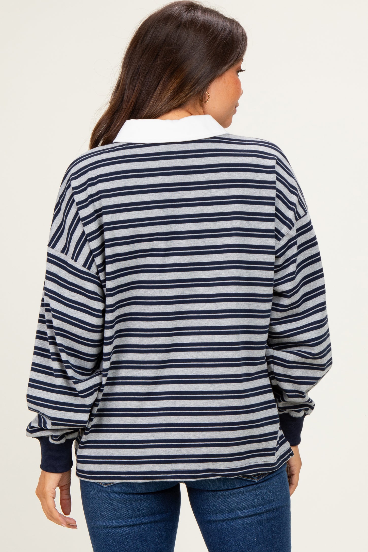 woman wearing a striped maternity sweatshirt with long sleeves and a white collar, viewed from the back