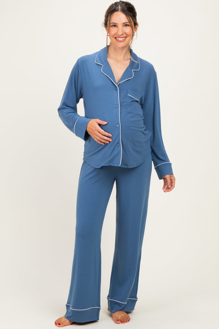 woman wearing a blue maternity pajama set with white piping and a visible baby bump