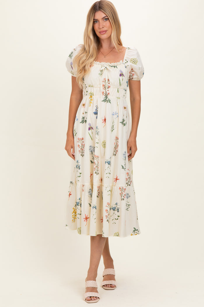 woman wearing a cream floral print midi dress with puff sleeves and smocked bodice