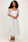 woman wearing a white and light blue floral lace midi dress with sheer puff sleeves and pointed toe heels