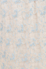 maternity wear featuring white fabric with intricate blue floral embroidery and delicate detailing