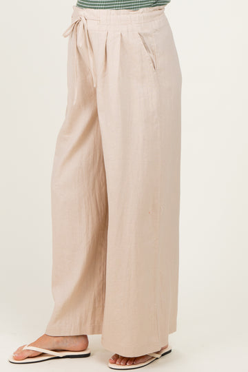 woman wearing light beige wide-leg maternity pants with a drawstring waist and side pockets