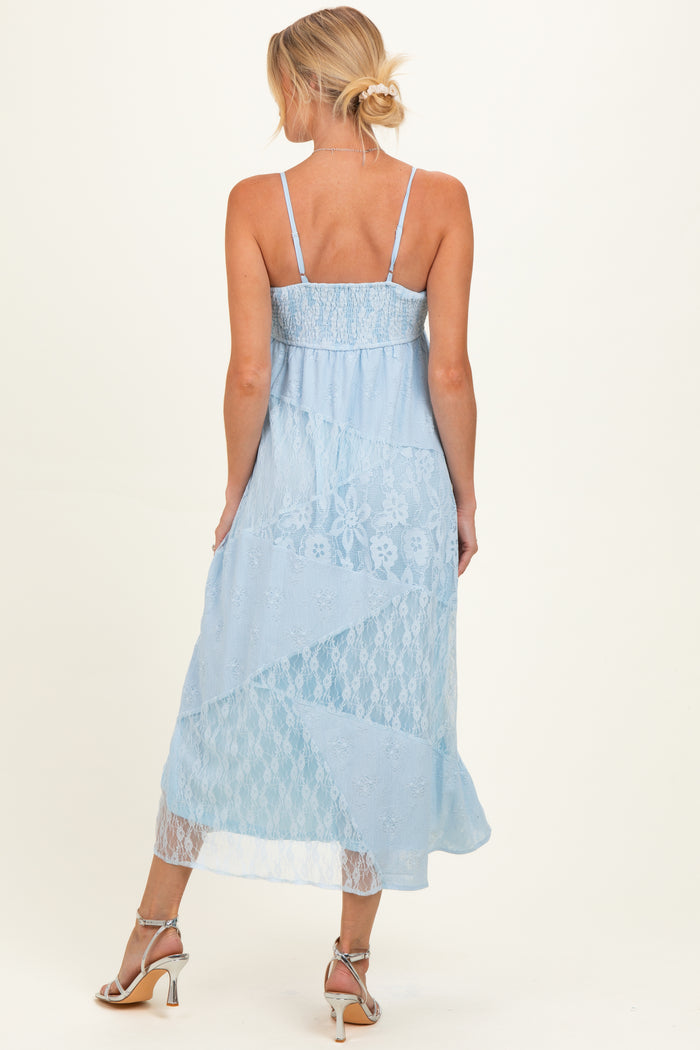 woman wearing a light blue lace maternity dress with adjustable straps and a flowy hem, showing off her baby bump