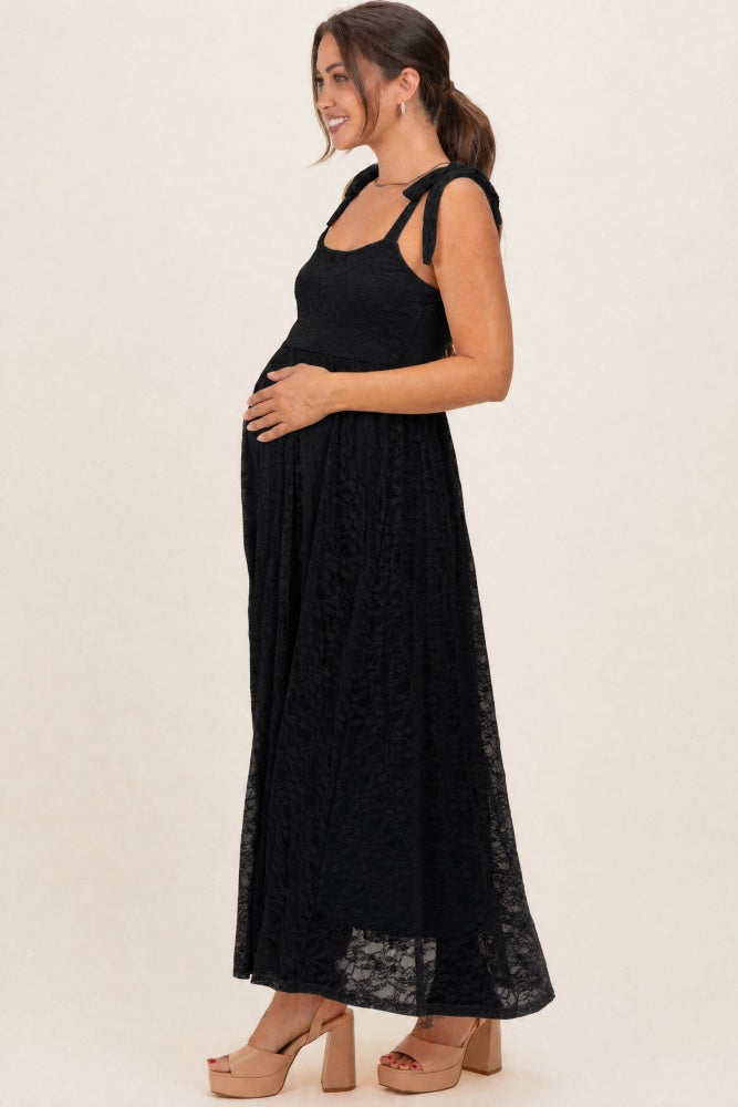 woman wearing a black lace maternity maxi dress with tie straps and a visible baby bump
