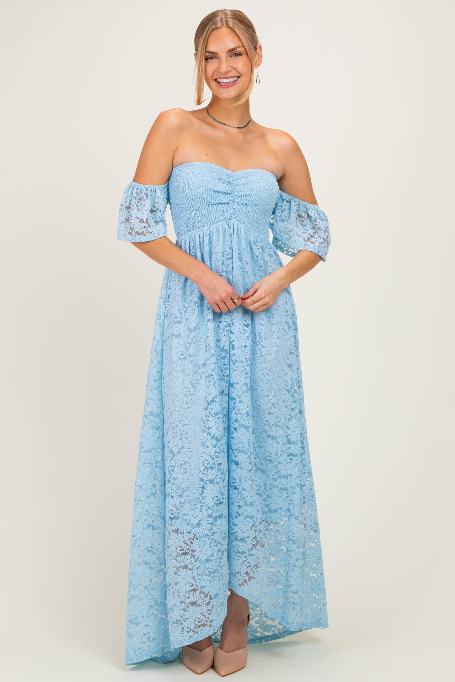 woman wearing a light blue off-the-shoulder lace maxi dress with bell sleeves and a fitted bodice
