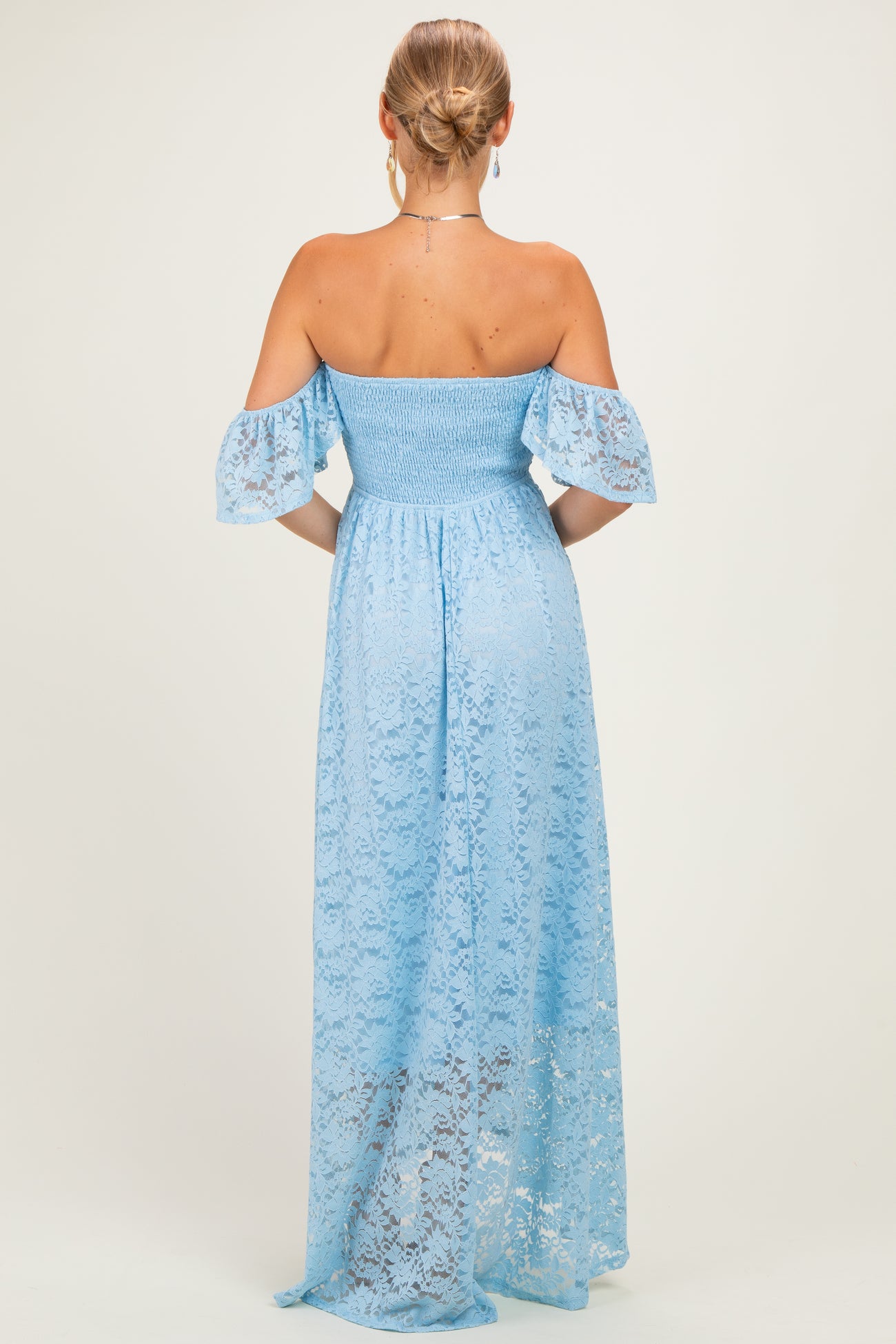 woman wearing a light blue off-the-shoulder lace maxi dress with smocked bodice and flutter sleeves