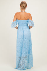 woman wearing a light blue off-the-shoulder lace maxi dress with smocked bodice and flutter sleeves