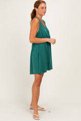 woman wearing a teal sleeveless ribbed dress with a tiered silhouette and flowy fit