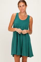 woman wearing a green ribbed sleeveless dress with a fitted bodice and flared skirt