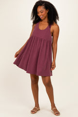 woman wearing a burgundy striped sleeveless sundress with a flared skirt and a relaxed fit