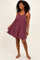 woman wearing a burgundy striped sleeveless sundress with a flared skirt and a relaxed fit