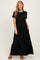 woman wearing a black short sleeve maxi dress with a gathered waist and side pockets