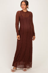woman wearing a rust lace long sleeve maternity dress with a fitted silhouette and a flowing hem, showcasing her baby bump