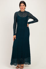 woman wearing a teal long sleeve lace maxi dress with a fitted silhouette and a flared hem