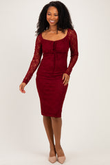 woman wearing a burgundy fitted lace dress with long sleeves and a square neckline
