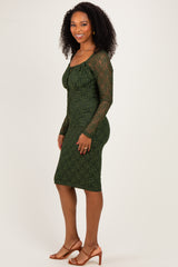 woman wearing a dark green lace long sleeve dress with a fitted silhouette and mid-length hemline