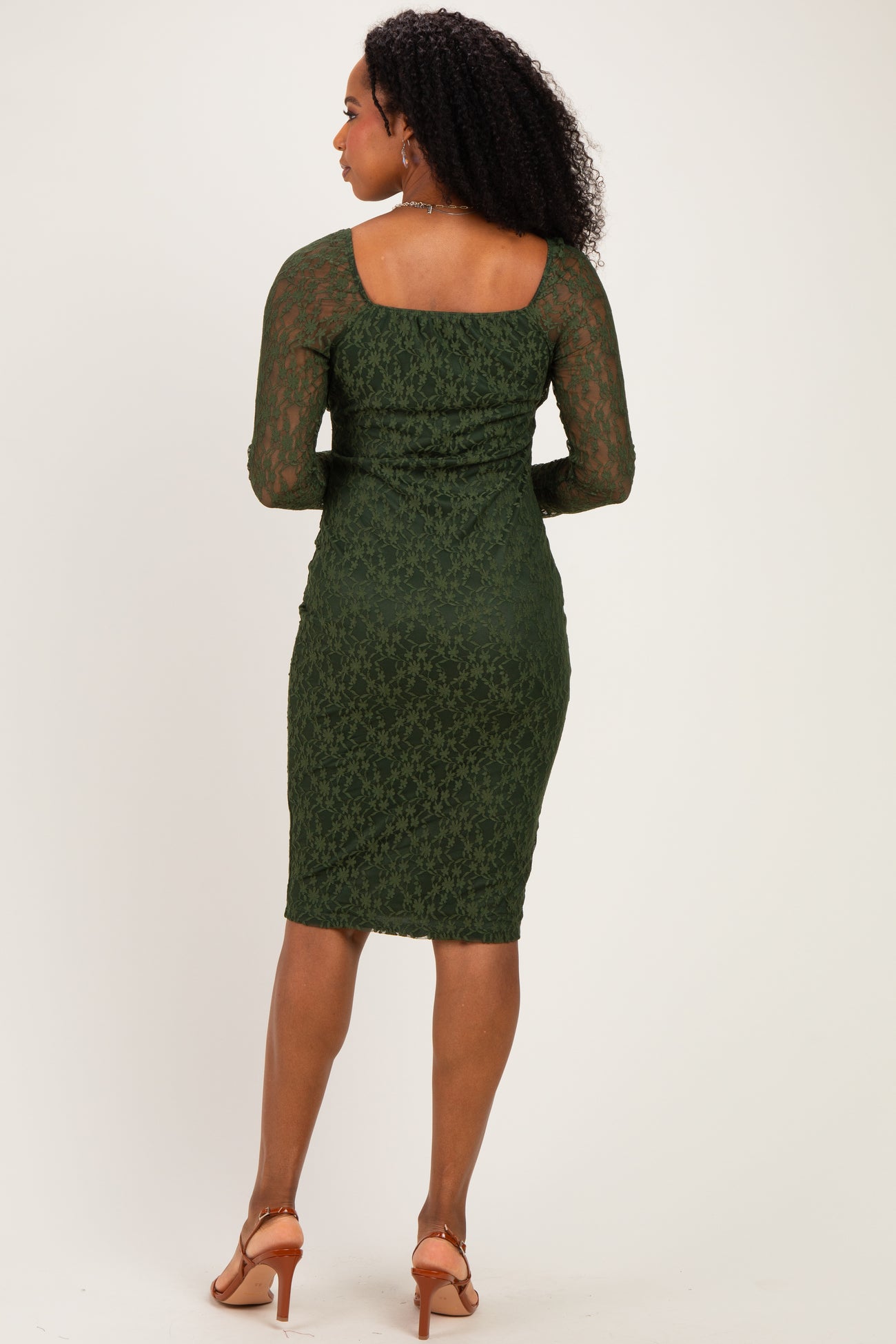 woman wearing a green lace midi dress with three-quarter sleeves and a fitted silhouette, viewed from the back