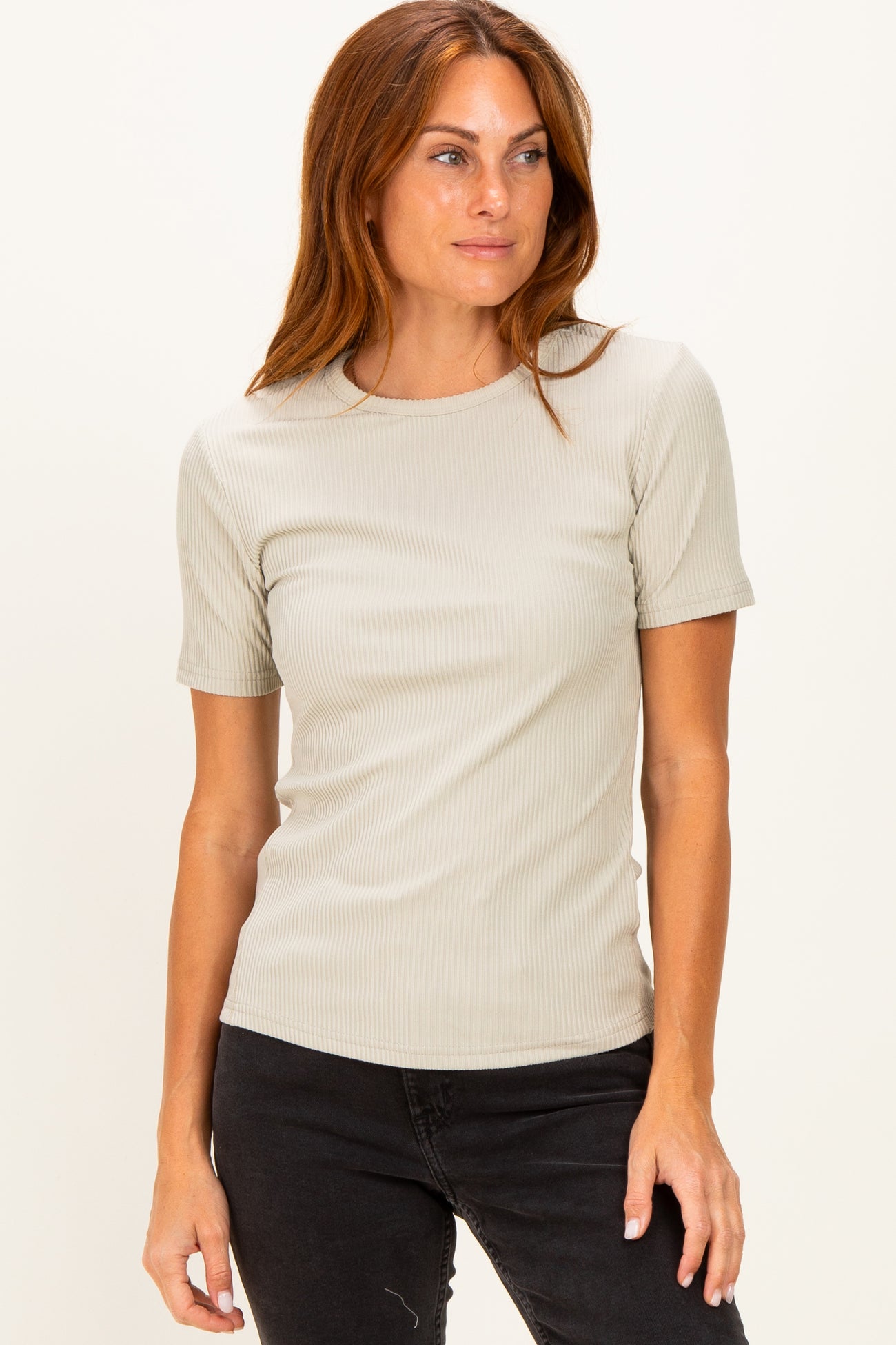woman wearing a light beige ribbed short sleeve top and black jeans