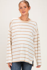 woman wearing a cream and caramel striped maternity top with a relaxed fit and visible baby bump