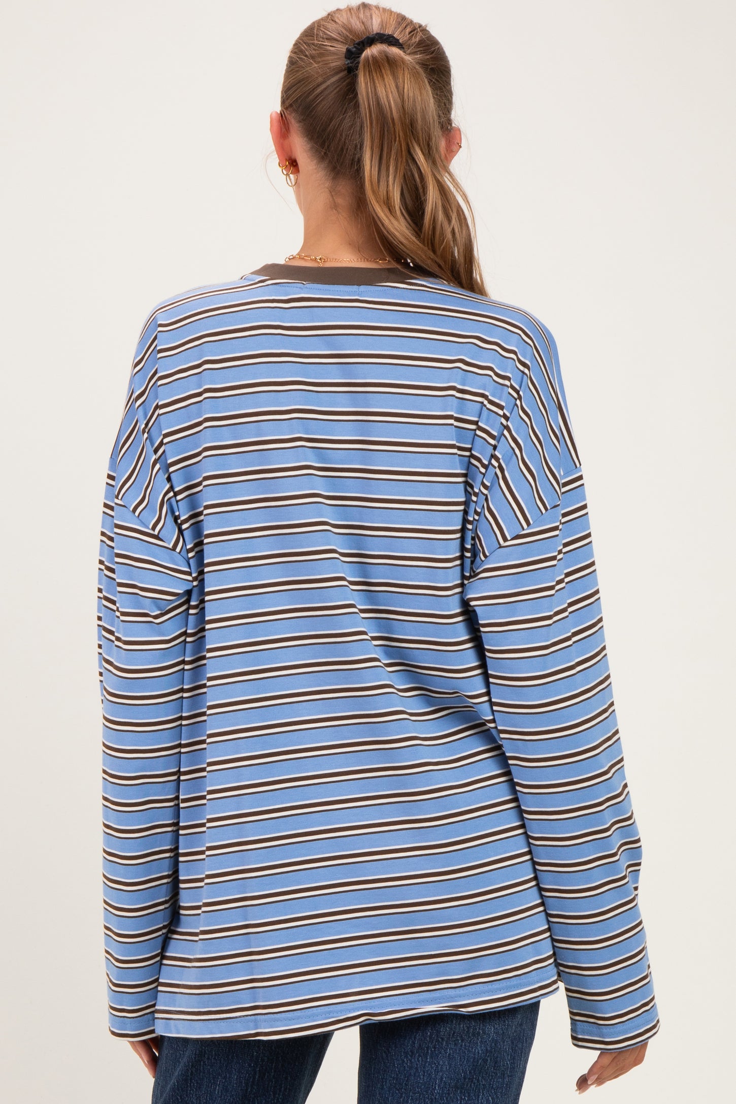 woman wearing a blue and brown striped maternity top with long sleeves, shown from the back