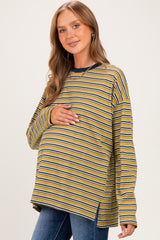 woman wearing a mustard yellow and navy striped maternity top and holding her baby bump
