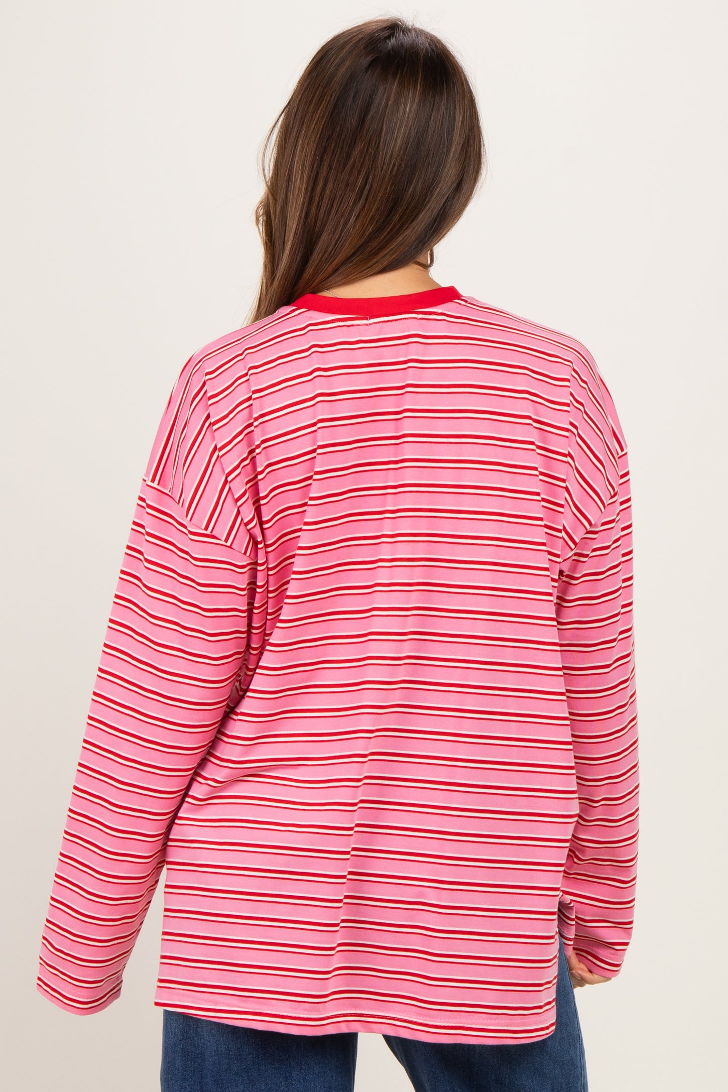woman wearing a red and pink striped maternity long sleeve top, viewed from the back