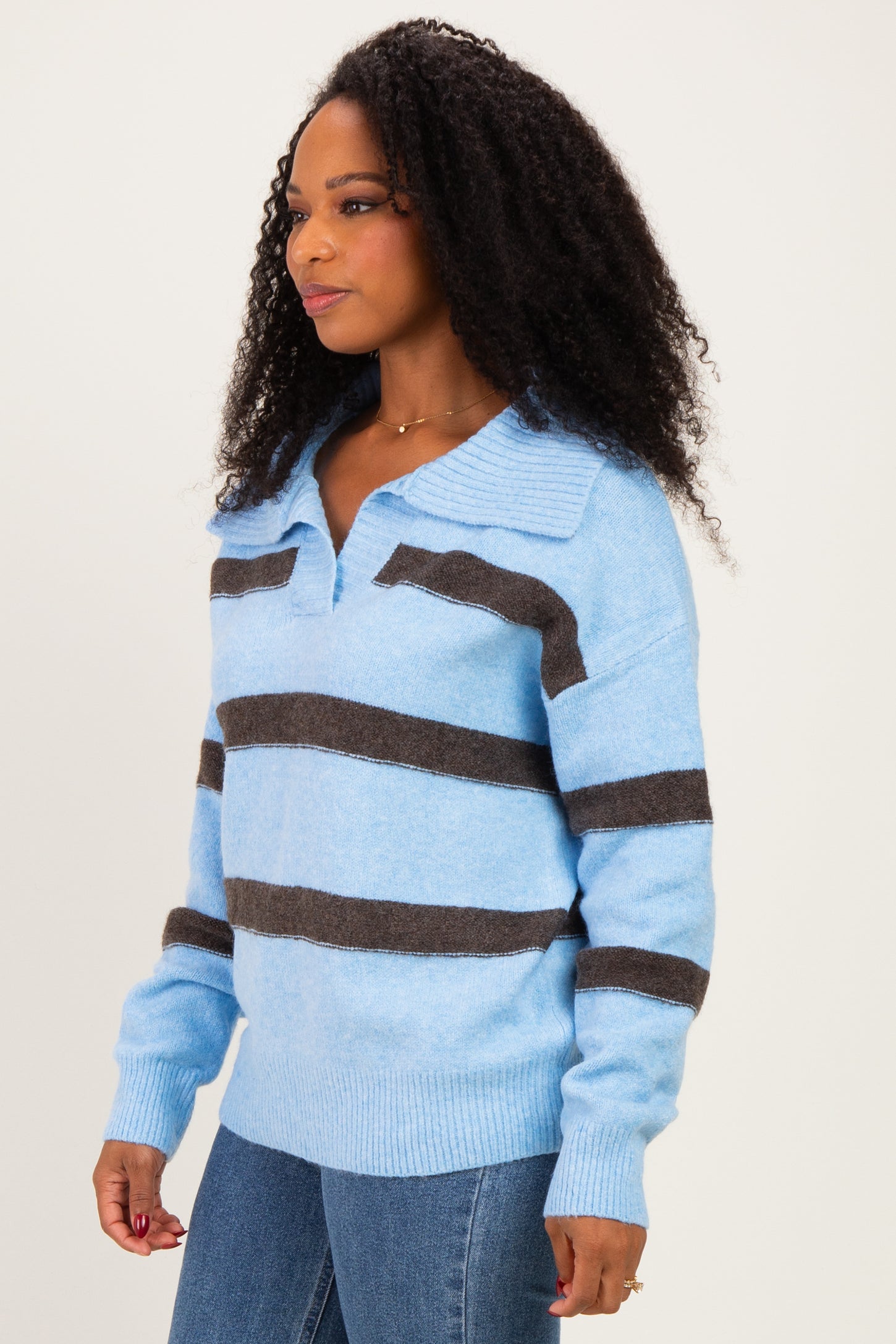 woman wearing a light blue striped sweater with dark brown horizontal stripes and a collared neckline