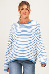 woman wearing a striped light blue and white oversized maternity sweater with a relaxed fit