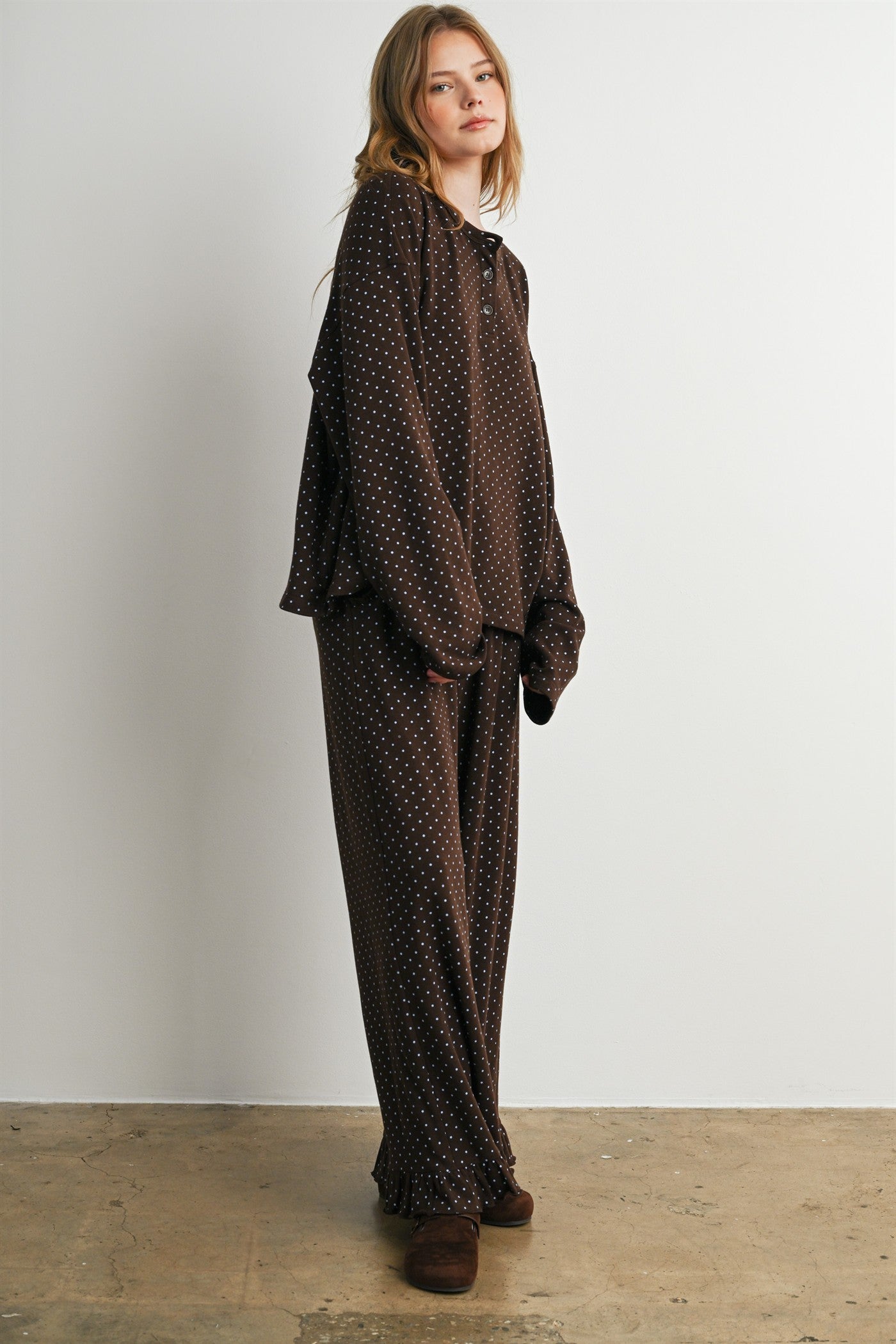 woman wearing a brown polka dot loungewear set with a relaxed fit top and matching pants