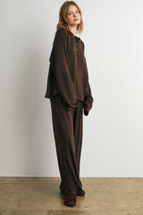woman wearing a brown polka dot loungewear set with a relaxed fit top and matching pants