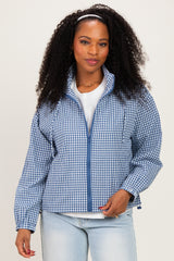 woman wearing a blue and white checkered zip-up jacket and light blue jeans