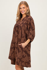 woman wearing a brown paisley print oversized dress with pockets and three-quarter sleeves