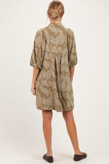 woman wearing an olive green maternity dress with a floral pattern and puff sleeves, showing the back view