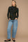 woman wearing a dark green floral long sleeve maternity top and distressed light blue jeans