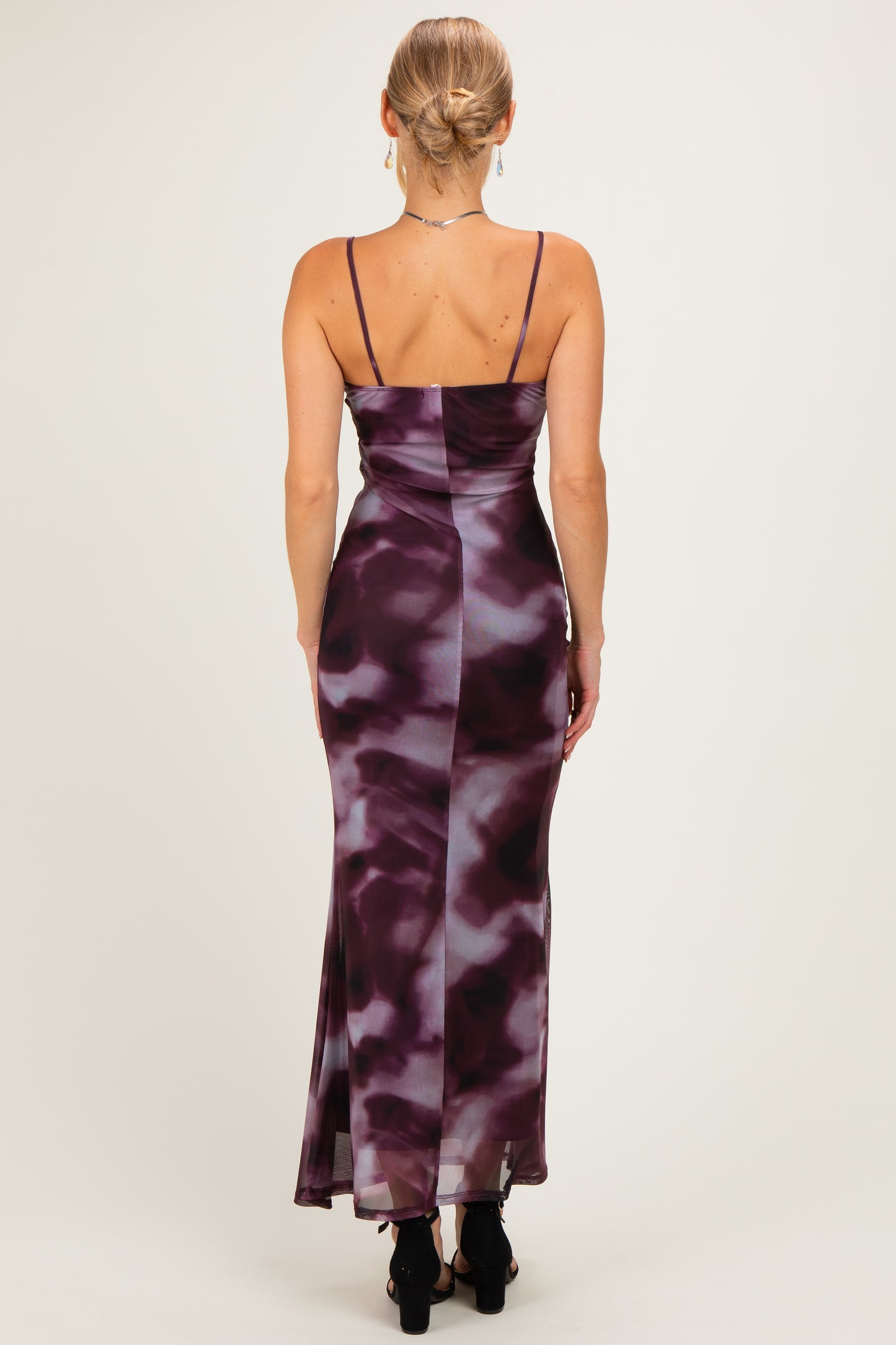 woman wearing a purple and white tie-dye maxi dress with thin straps, showing the back view