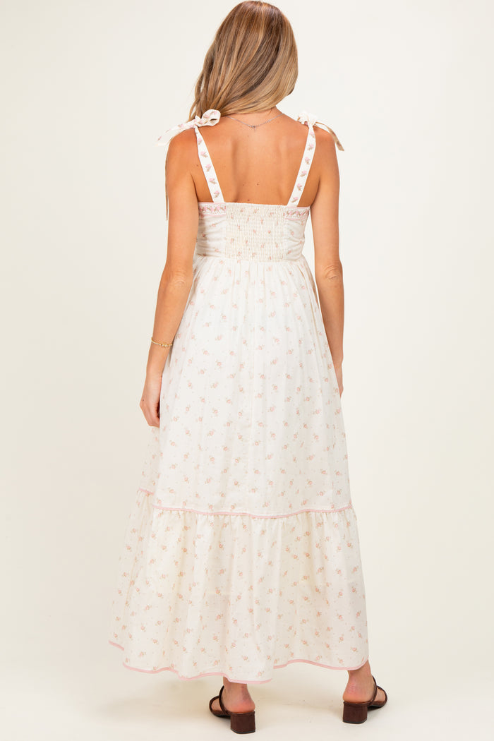 woman wearing a floral print maternity maxi dress with a smocked back and tie straps