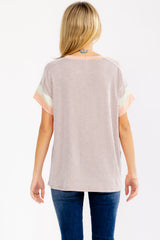 woman wearing a striped short sleeve top with orange and green color block details, viewed from the back