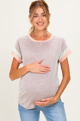 woman wearing a striped maternity top with short sleeves and holding her baby bump