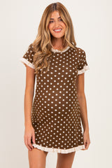 woman wearing a brown polka dot maternity dress with short sleeves and a scalloped hem, showcasing her baby bump