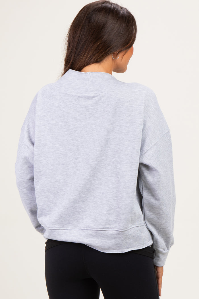 woman wearing a light grey maternity sweatshirt from the back, styled with black leggings
