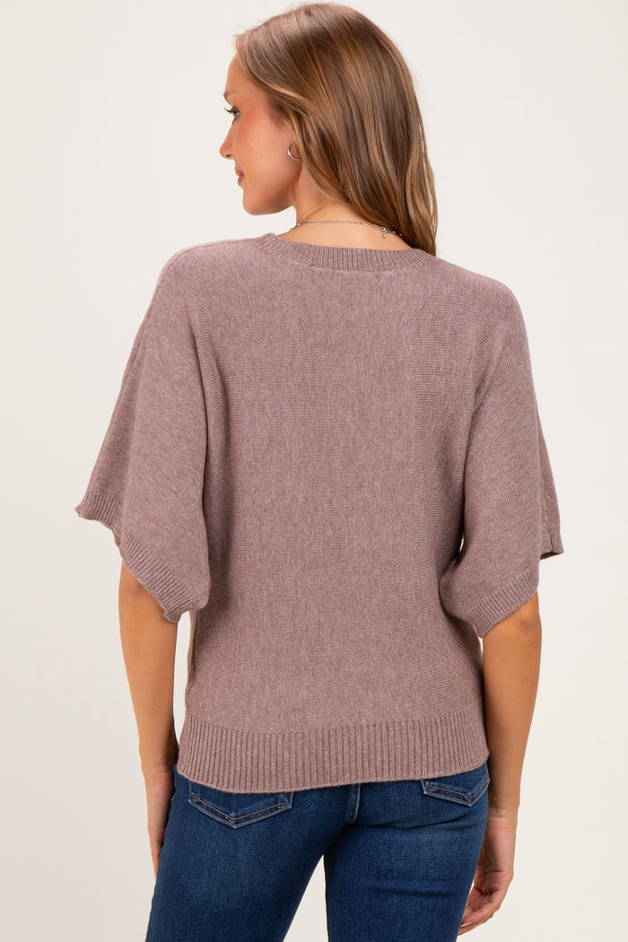 woman wearing a mauve oversized maternity sweater with short sleeves, viewed from the back