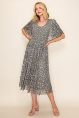 woman wearing a gray floral midi dress with short flutter sleeves and a fitted bodice