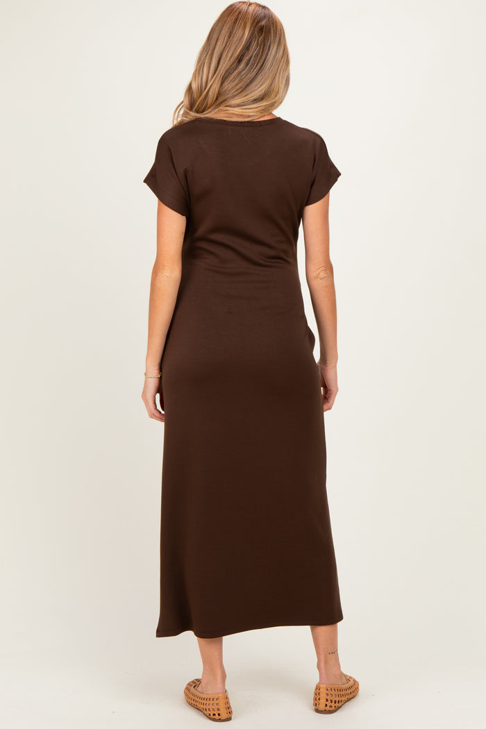 woman wearing a brown maternity maxi dress, shown from the back, with short sleeves and a relaxed fit