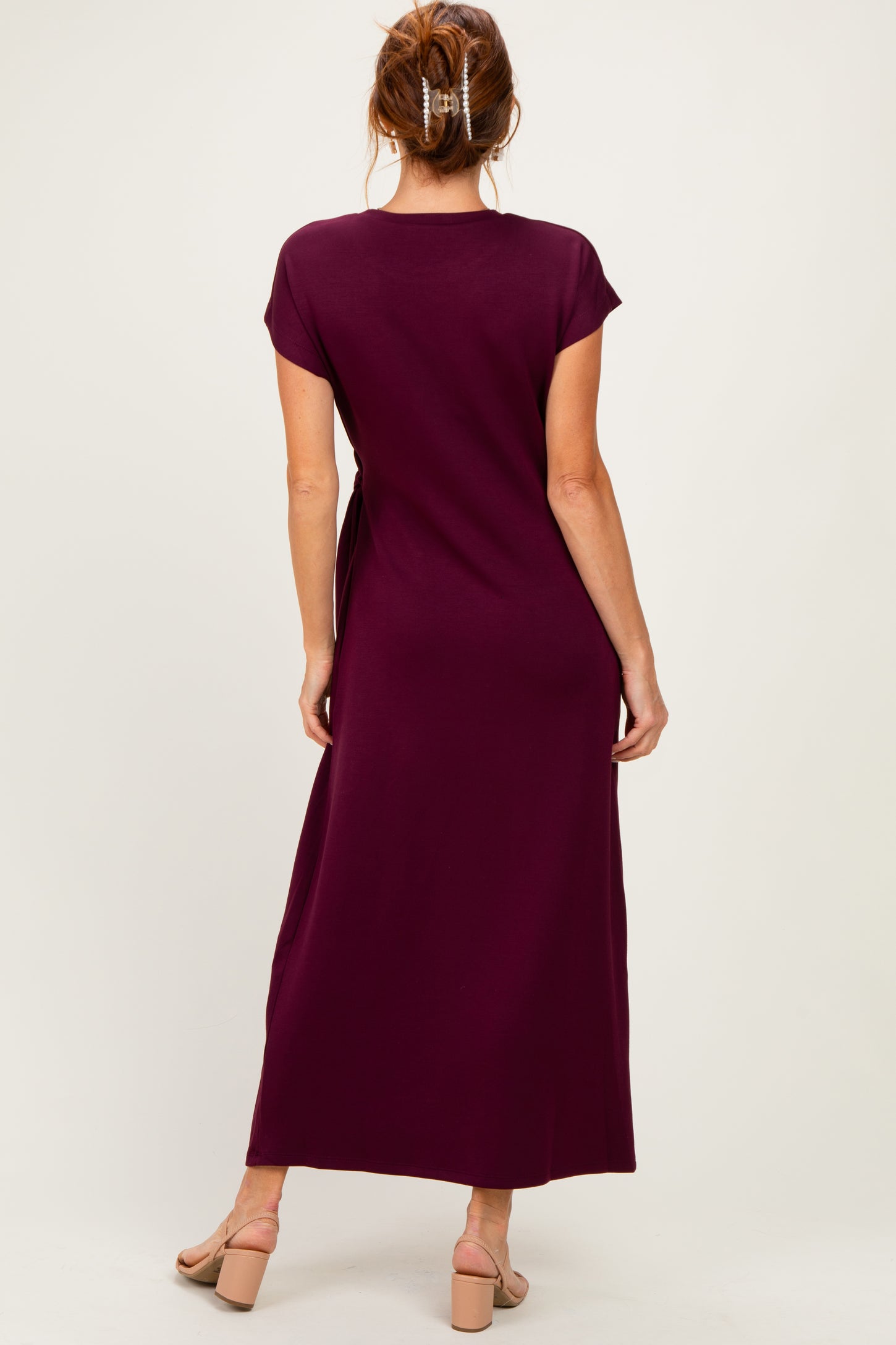 woman wearing a burgundy maxi dress with short sleeves, view from the back
