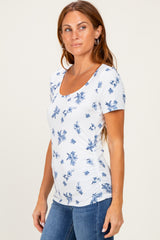 woman wearing a white floral print scoop neck t-shirt with short sleeves and ruched sides, paired with jeans
