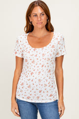 woman wearing a white short sleeve scoop neck top with a floral print and fitted silhouette