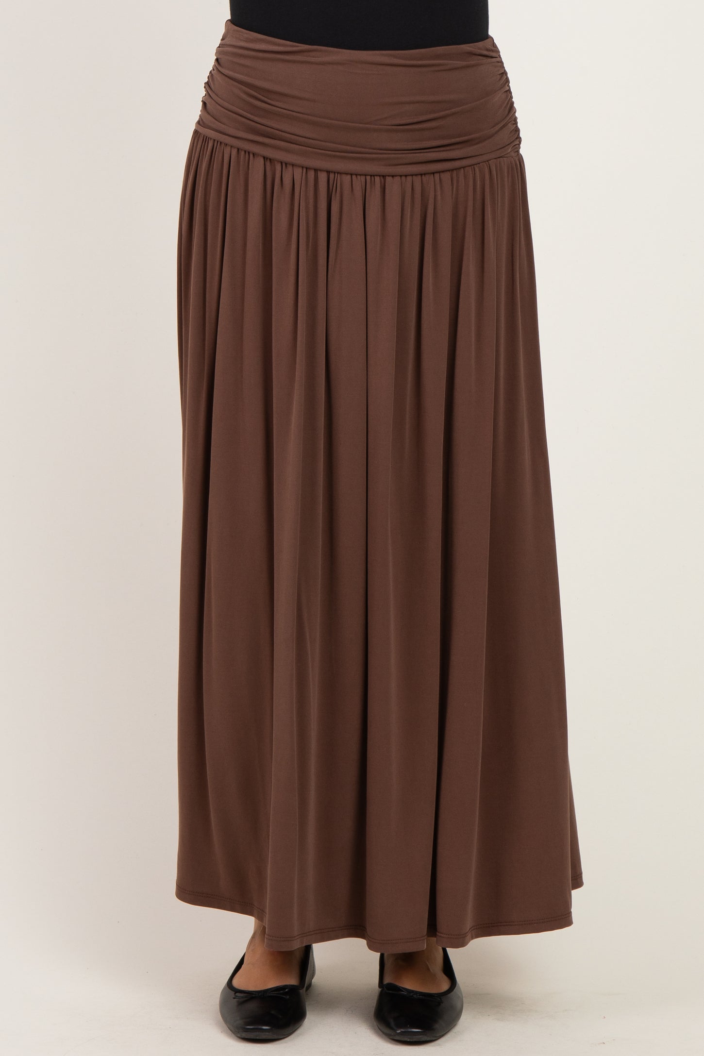 woman wearing a brown maxi skirt with a gathered waistband and flowing silhouette