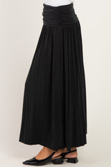 woman wearing a black maxi skirt with a ruched waistband and flowy silhouette