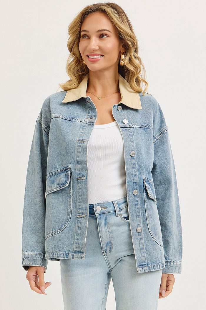 woman wearing a light blue denim jacket with a cream collar and front pockets, styled with a white top and light jeans